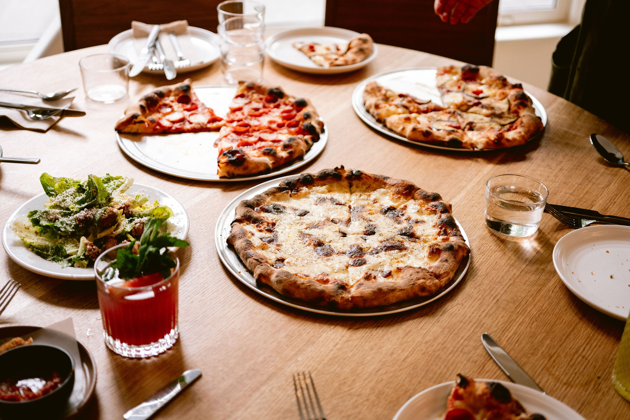 Pizzas and salads on a table