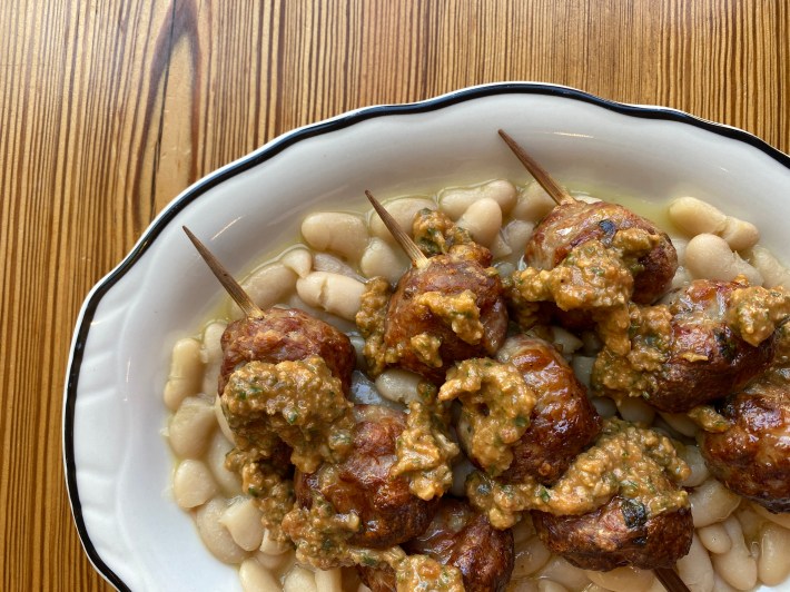 meatballs on skewers over white beans