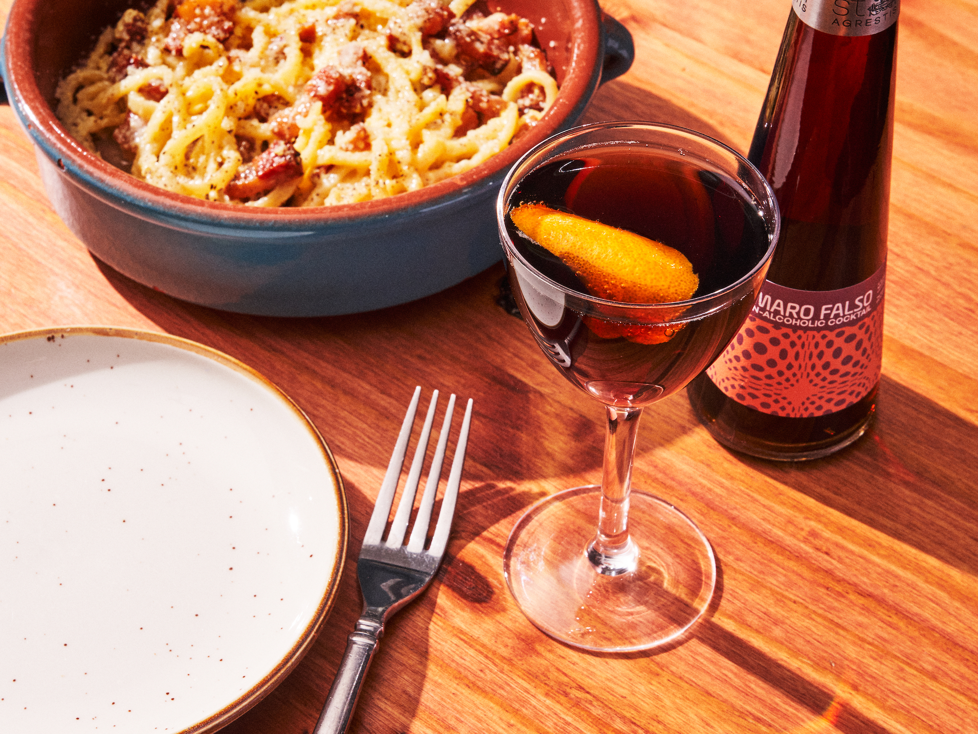 Amaro falso bottle, mocktail and bowl of pasta