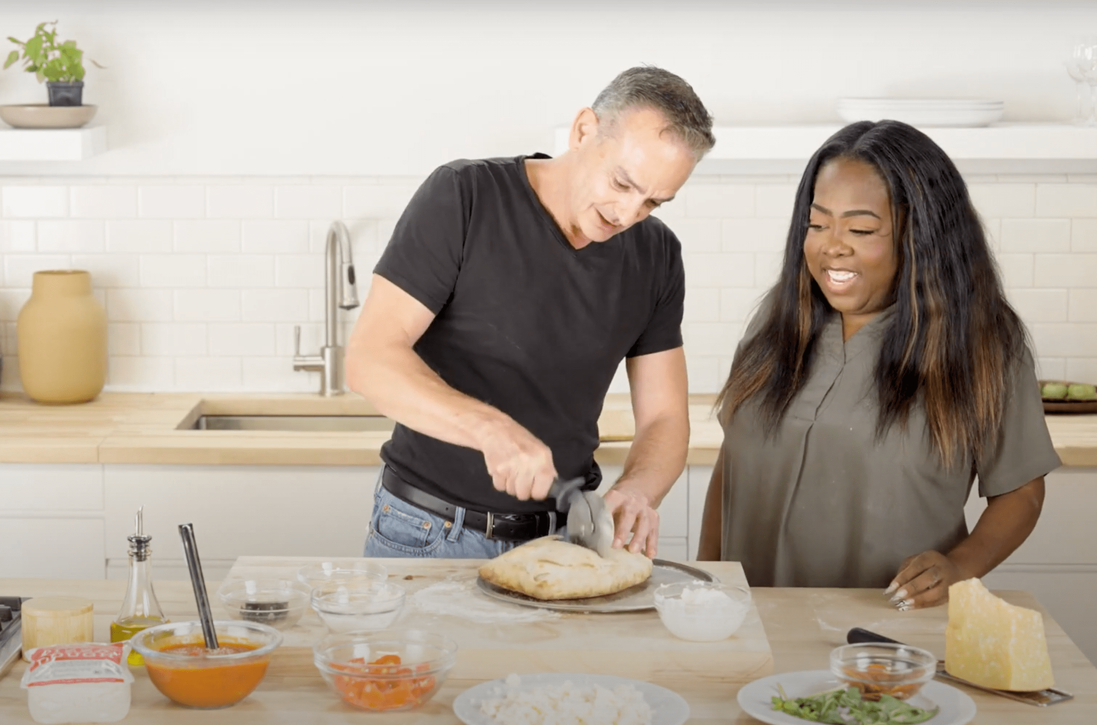 Andrew Cotto cuts open a calzone while Nicole Russell looks on.