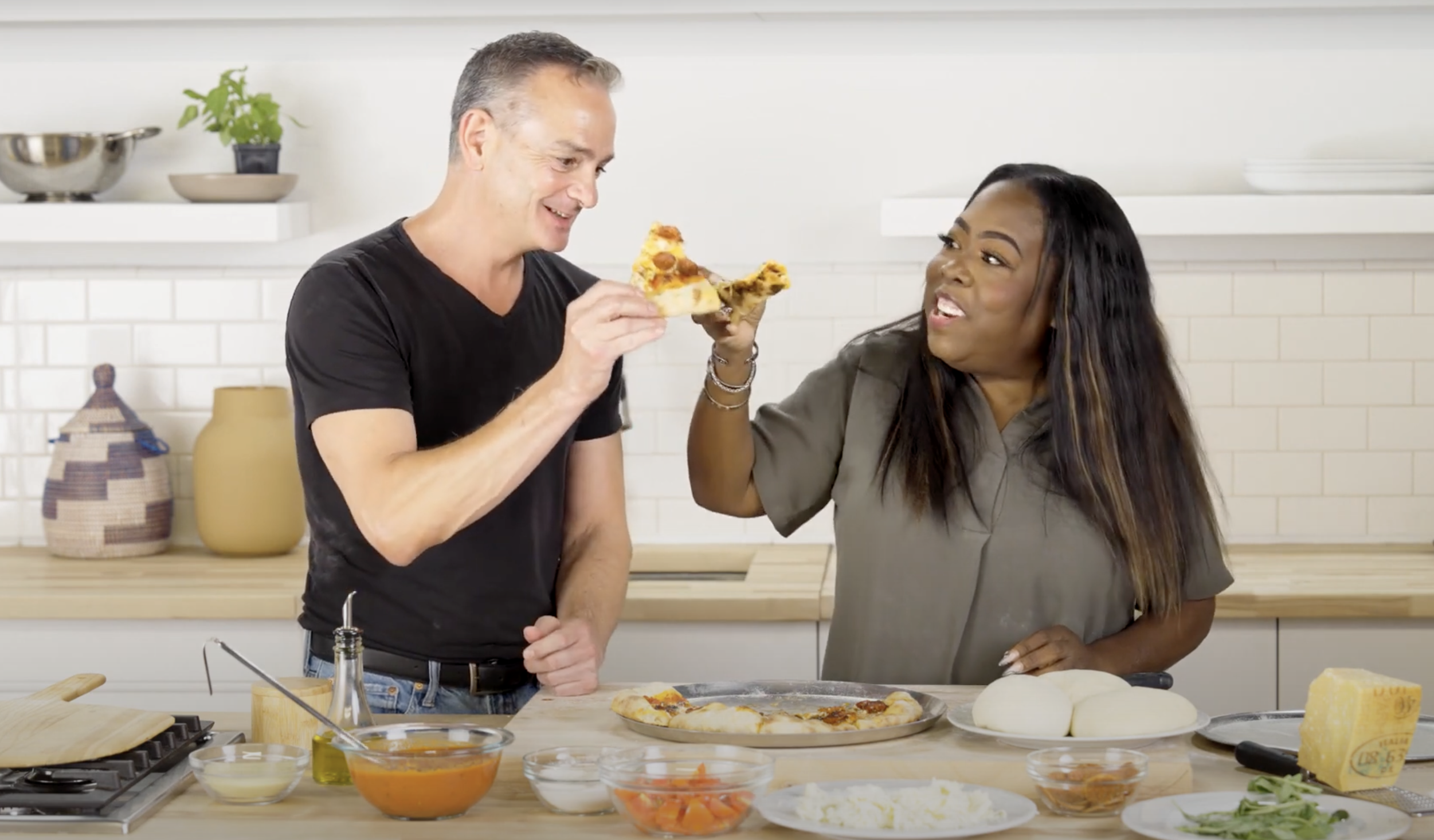 Andrew Cotto and Nicole Russell toast with pizza slices