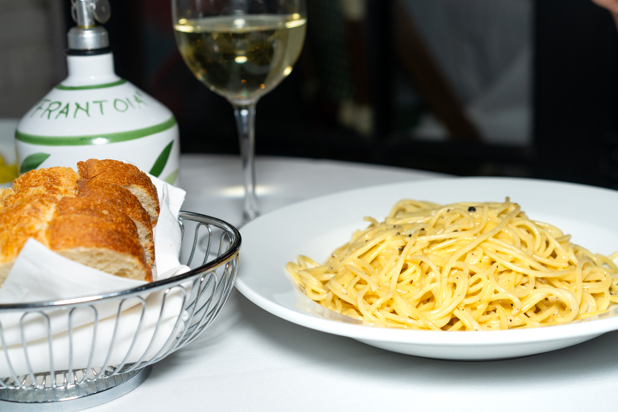 Cacio e pepe with bread and a glass of white wine