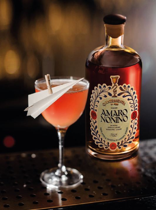Paper plane cocktail and bottle of amaro