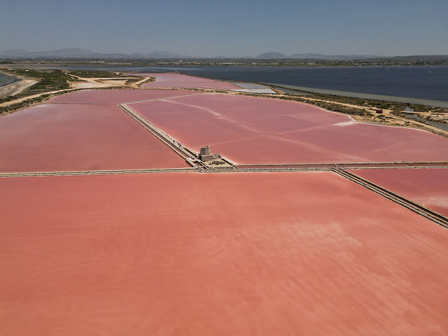 Aerial shot of the millennia old salt basins in Trapani, Sicily, who get their electric pink color from a unique microorganism that gives the salt its special quality.