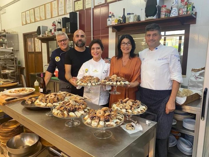 (From Left: Chef /Owner Salvatore Murano, Designer Giuseppe Fata, Chef Amy Riolo, Giovanna Giordano, General Director of Casa Italia Montreal, Chef Luigi Quintieri in the kitchen of Max Trattoria Enoteca in Cirò Marina, Calabria with Amy Riolo’s traditional cookie recipes.