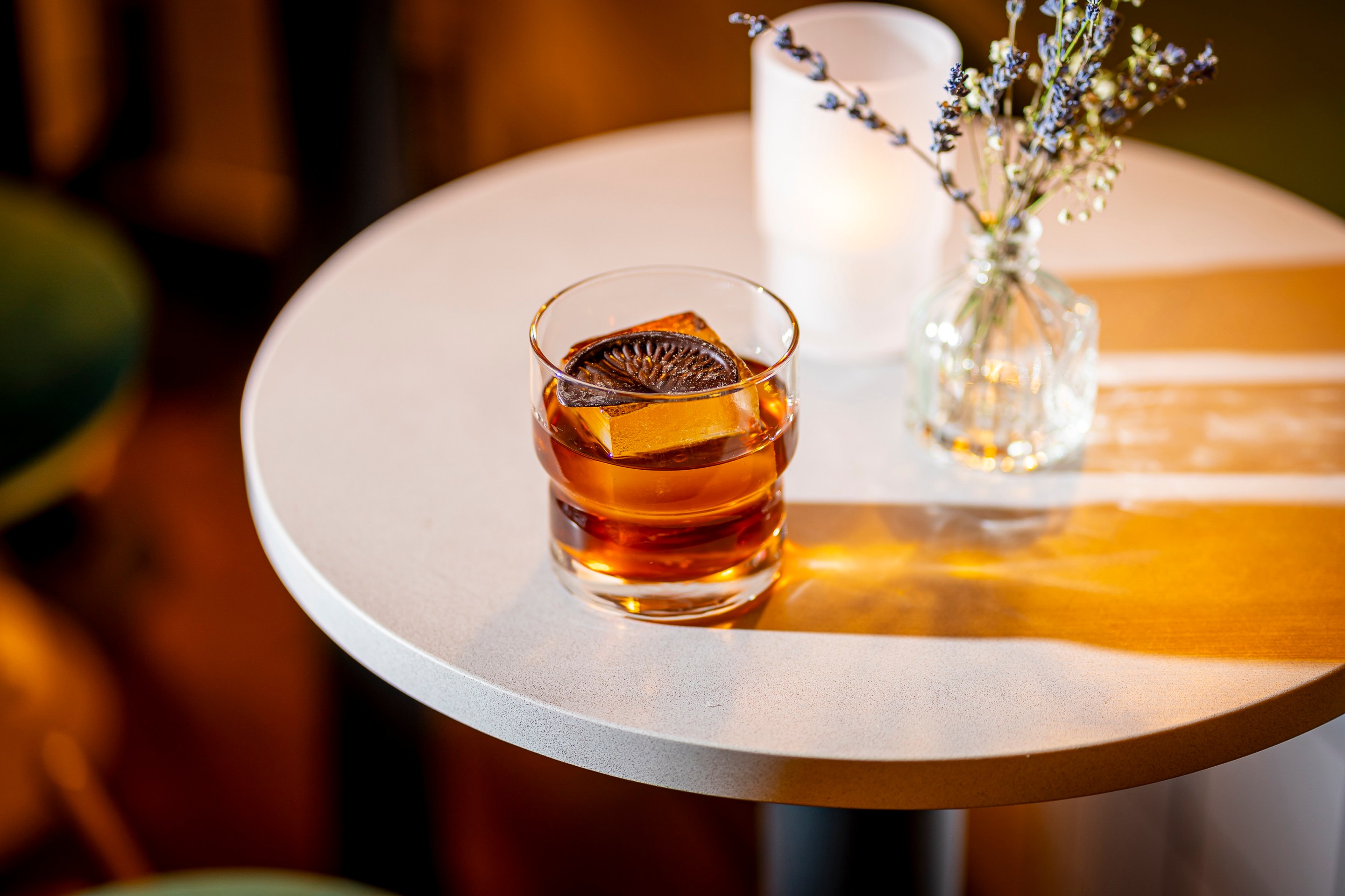 Chocolate Negroni on a table with candle and flowers