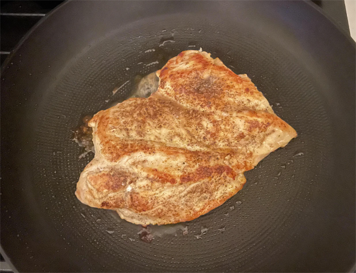 A chicken breast seared in an Imarku 12-inch Skillet.