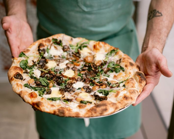 The Conrad at Flour + Water Pizza Shop with mushrooms, kale, taleggio, fresh mozzarella, red onion, and roasted garlic. Photo by Kristen Loken.
