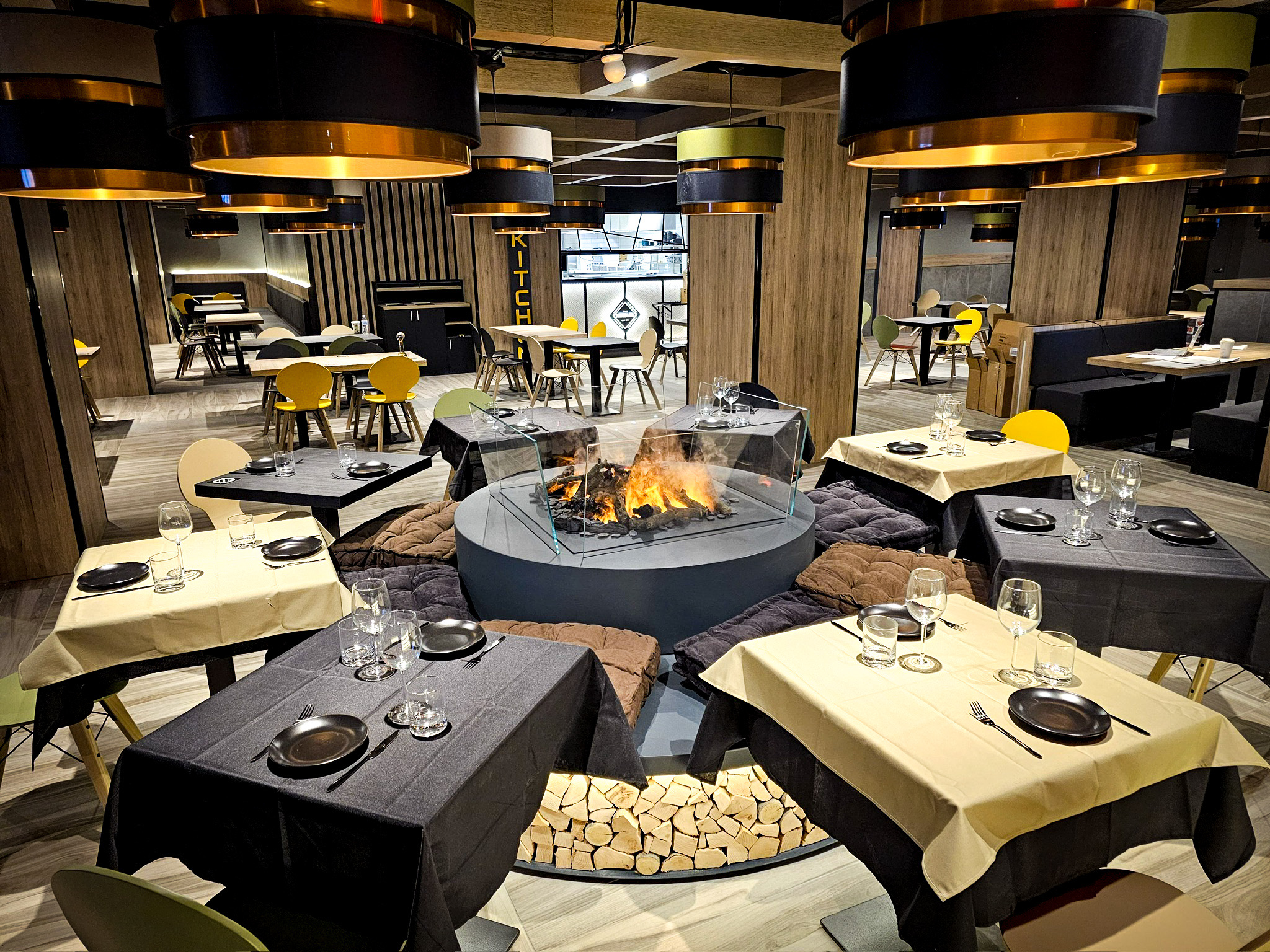 Dining room at NEROLAB’s 40 Wall Street location, featuring modern tables, gold-accented, and a central fireplace.