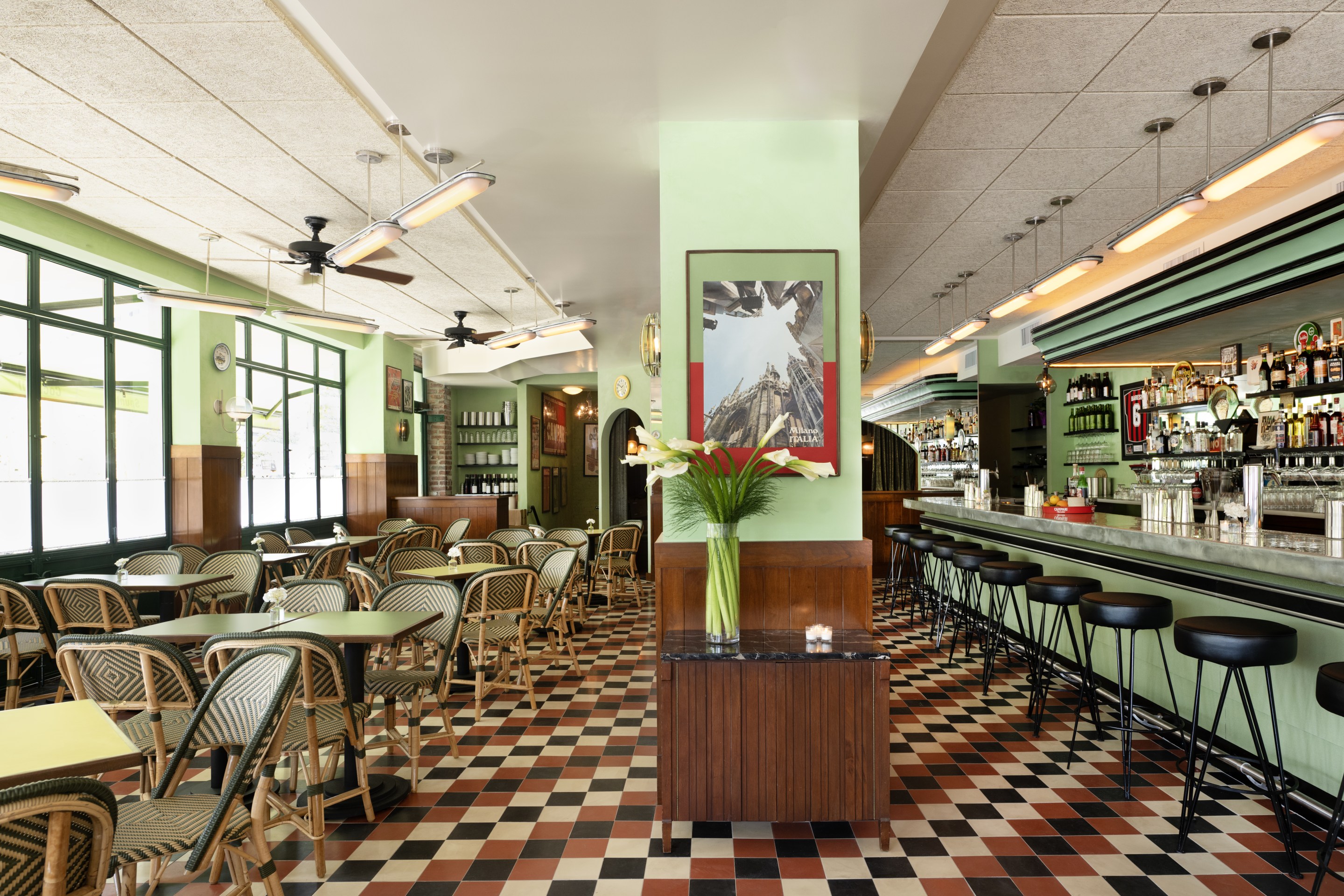 Daytime view of Bar Bianchi’s interior with green walls and a long bar.