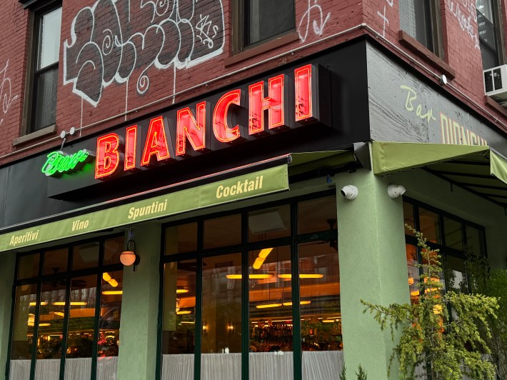 Exterior of Bar Bianchi with neon sign and green awning on the Lower East Side.
