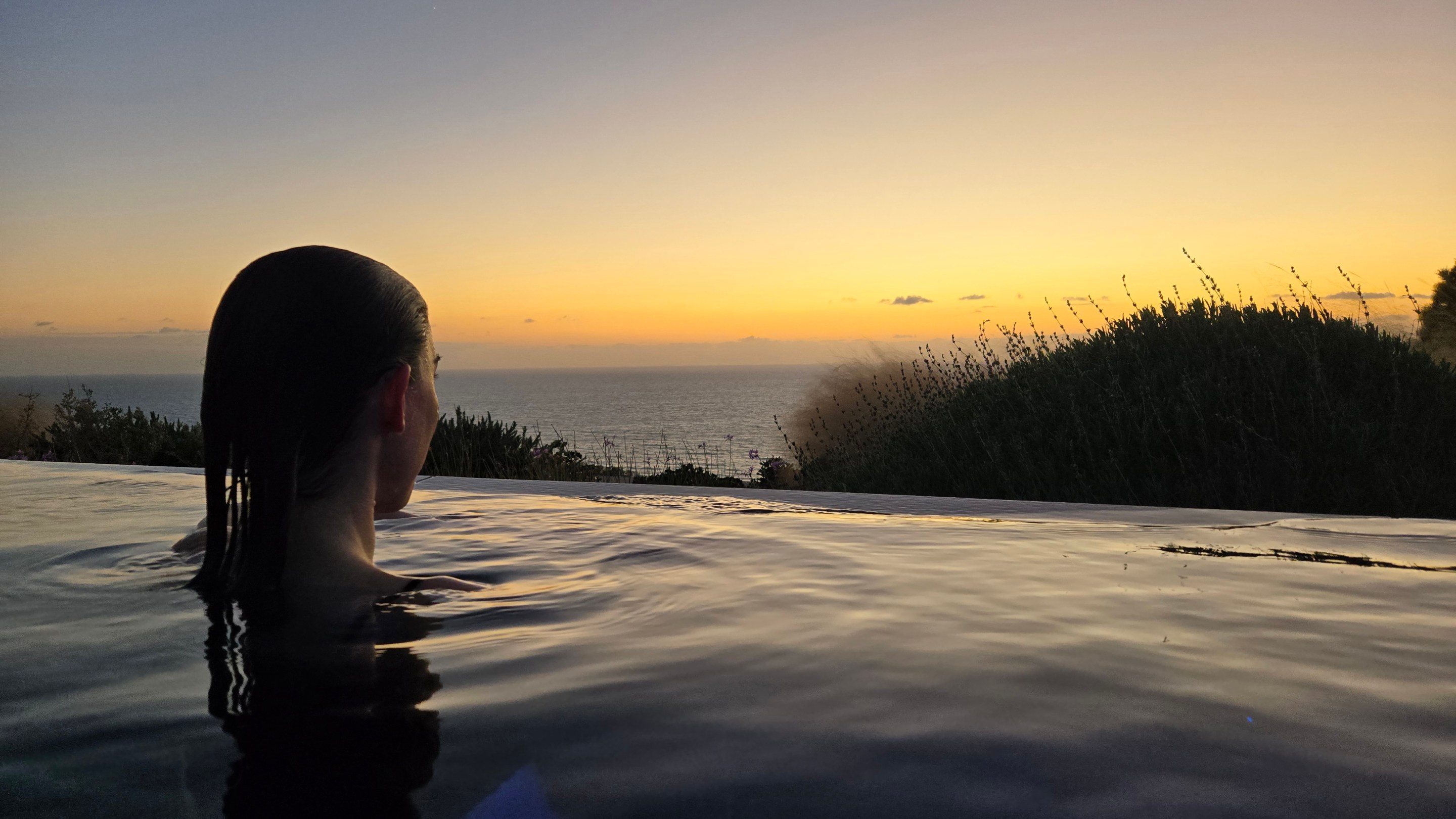 A bather watches the sunset from the Thalasso therapy pool in Sicily.