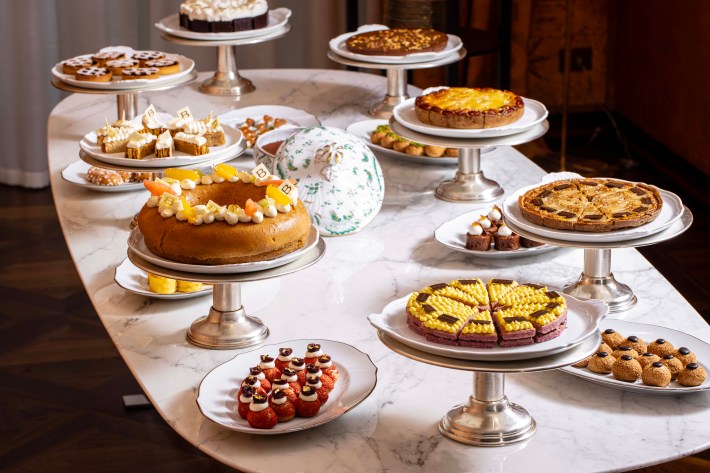 Assorted Italian cakes, tarts, and pastries arranged on silver stands in the dessert room.