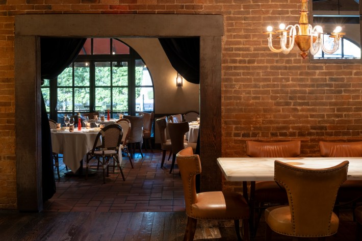 Interior view of Bottega with rustic brick walls and set tables