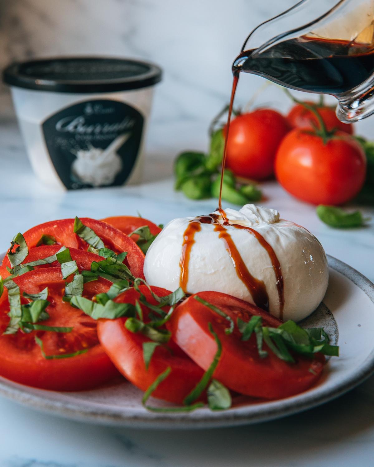 Burrata with sliced tomatoes and basil drizzled with balsamic