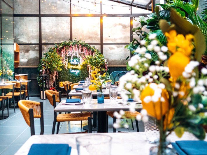 View of the full Limoncello Lounge interior with lemon-themed decor, string lights, and greenery