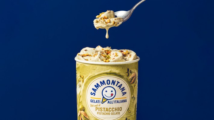 Spoon lifting a bite of pistachio gelato from a Sammontana Pistacchio pint