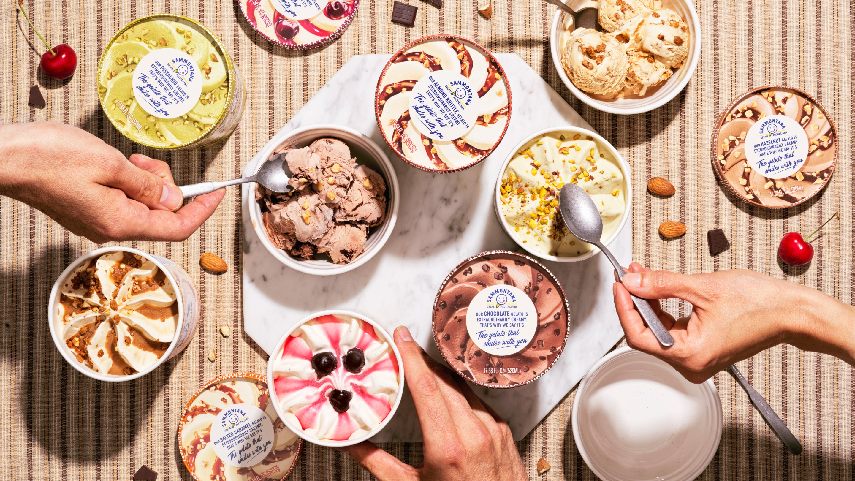 Multiple pints in various flavors, with hands and spoons reaching in.