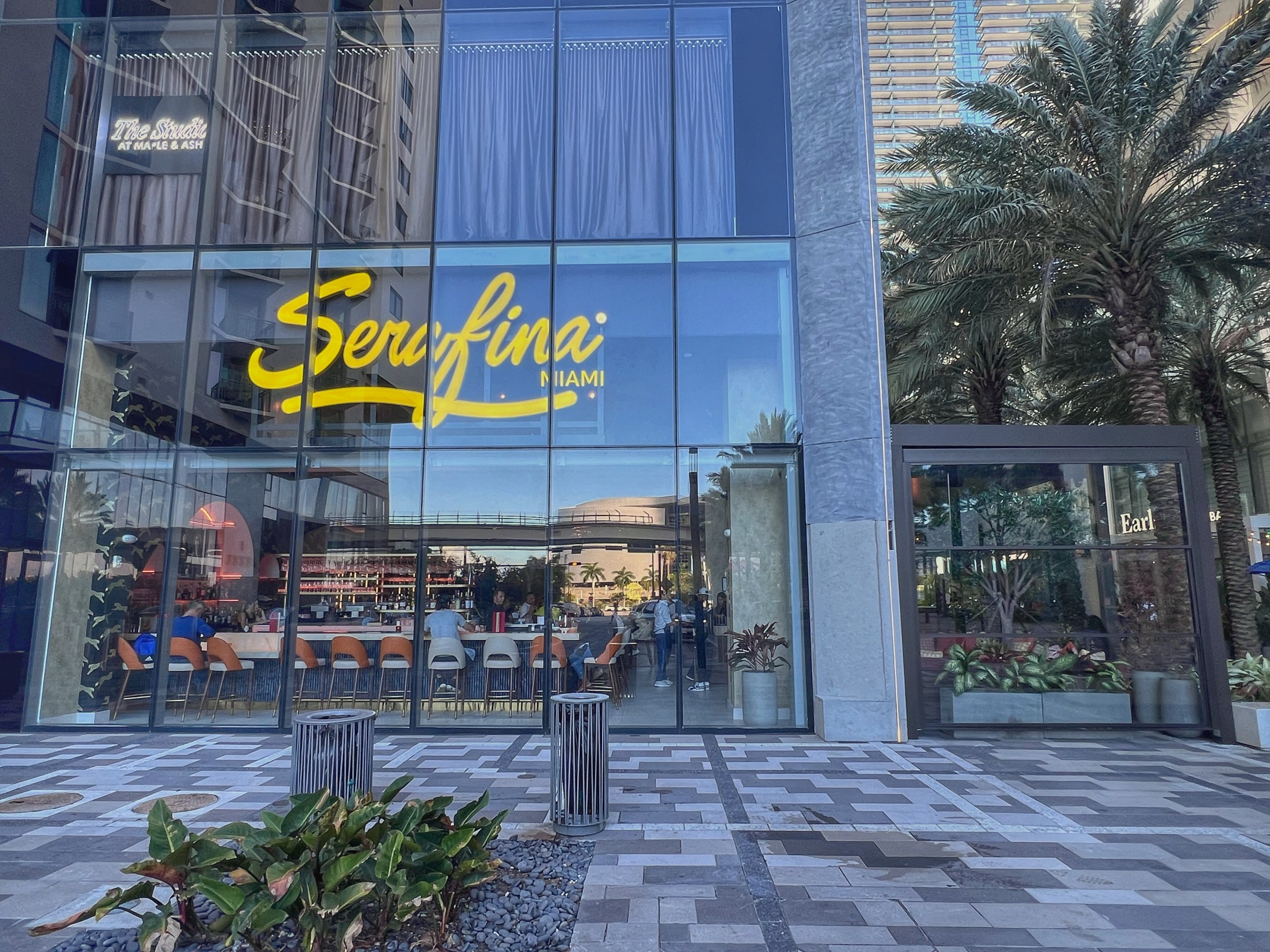 Exterior view of Serafina Miami with bright yellow sign and patio seating