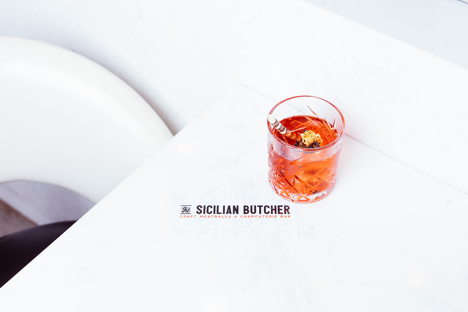 Red cocktail with garnish at The Sicilian Butcher North Dallas