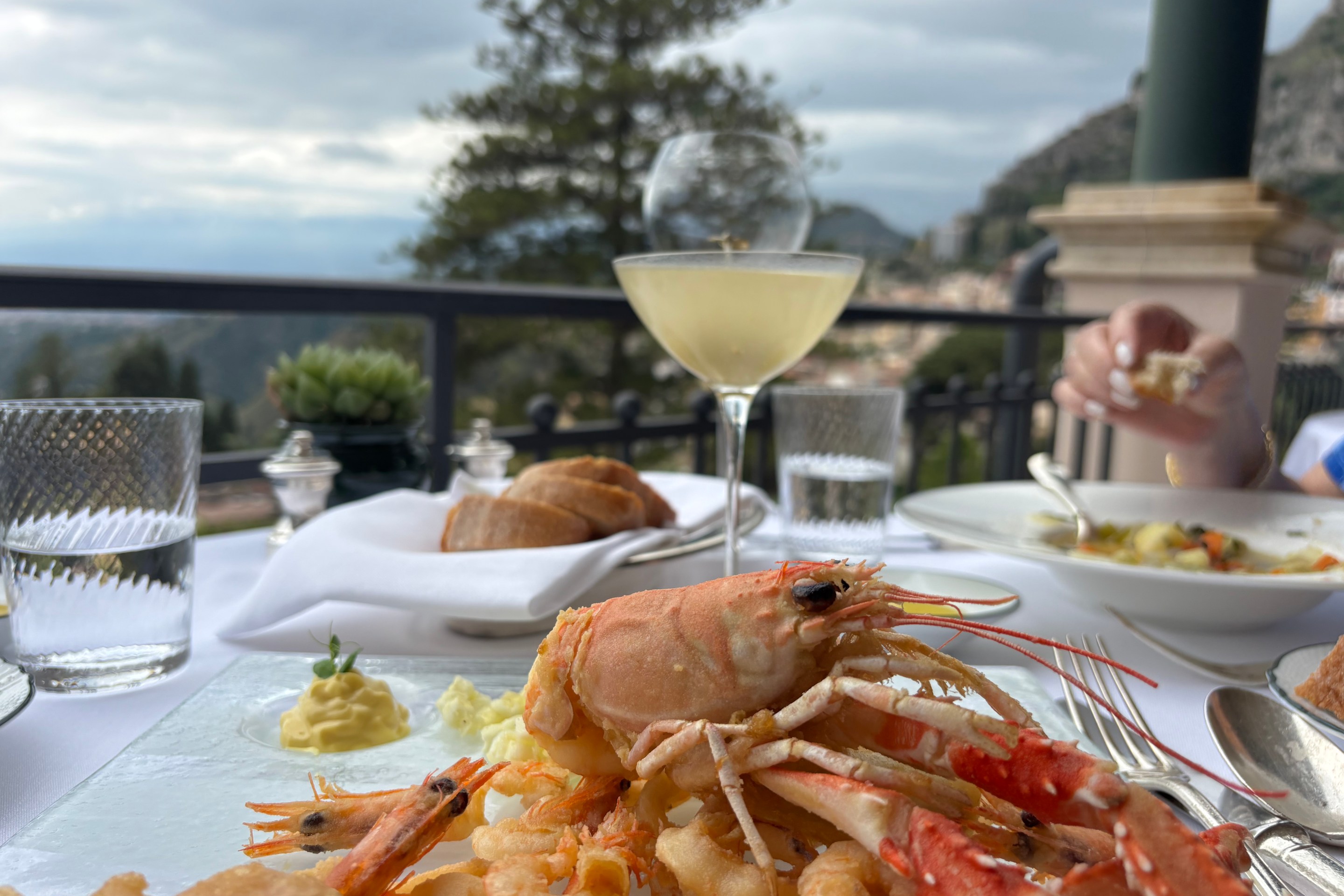 late of Sicilian seafood and a cocktail at a scenic outdoor restaurant