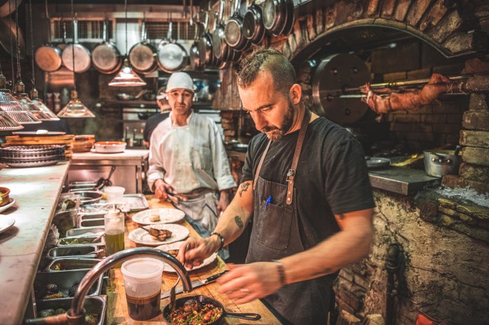 Chef Marc Forgione preparing food in the open kitchen at Peasant