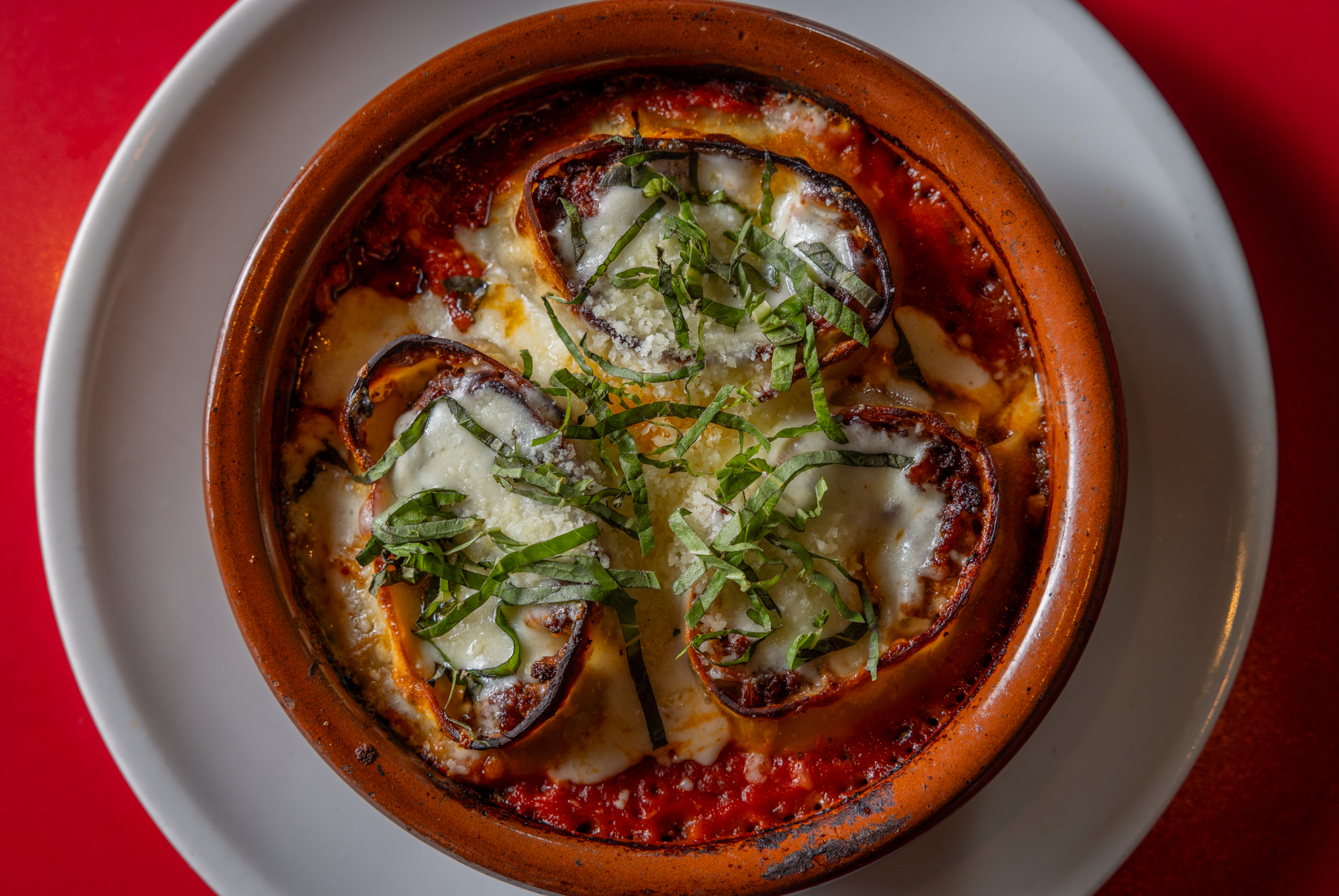 Close-up of Asti Trattoria’s Lasagna Rotolo baked with tomato sauce, melted cheese, and fresh basil .