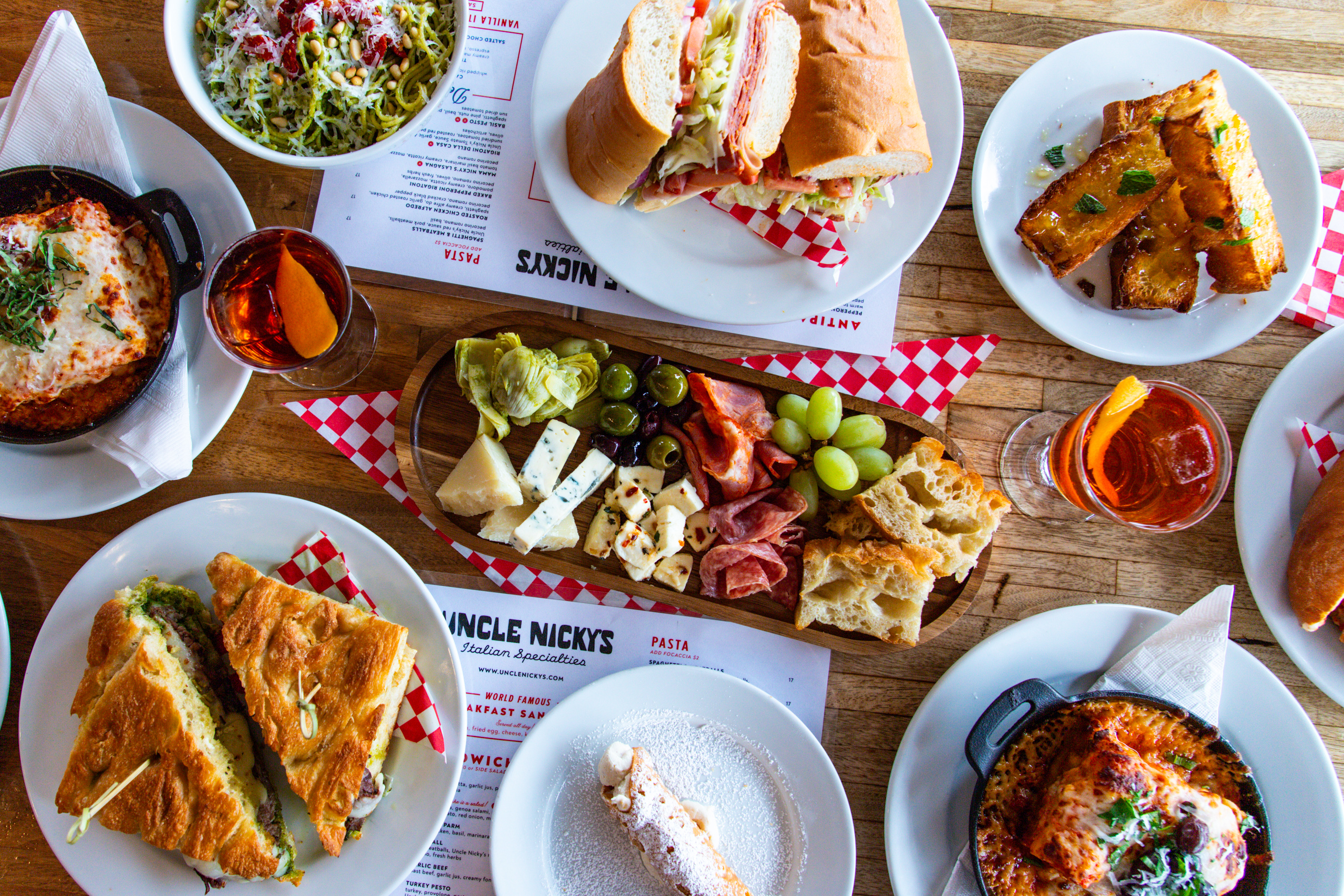 Overhead view of Italian-American dishes and Negronis at Uncle Nicky’s in Austin