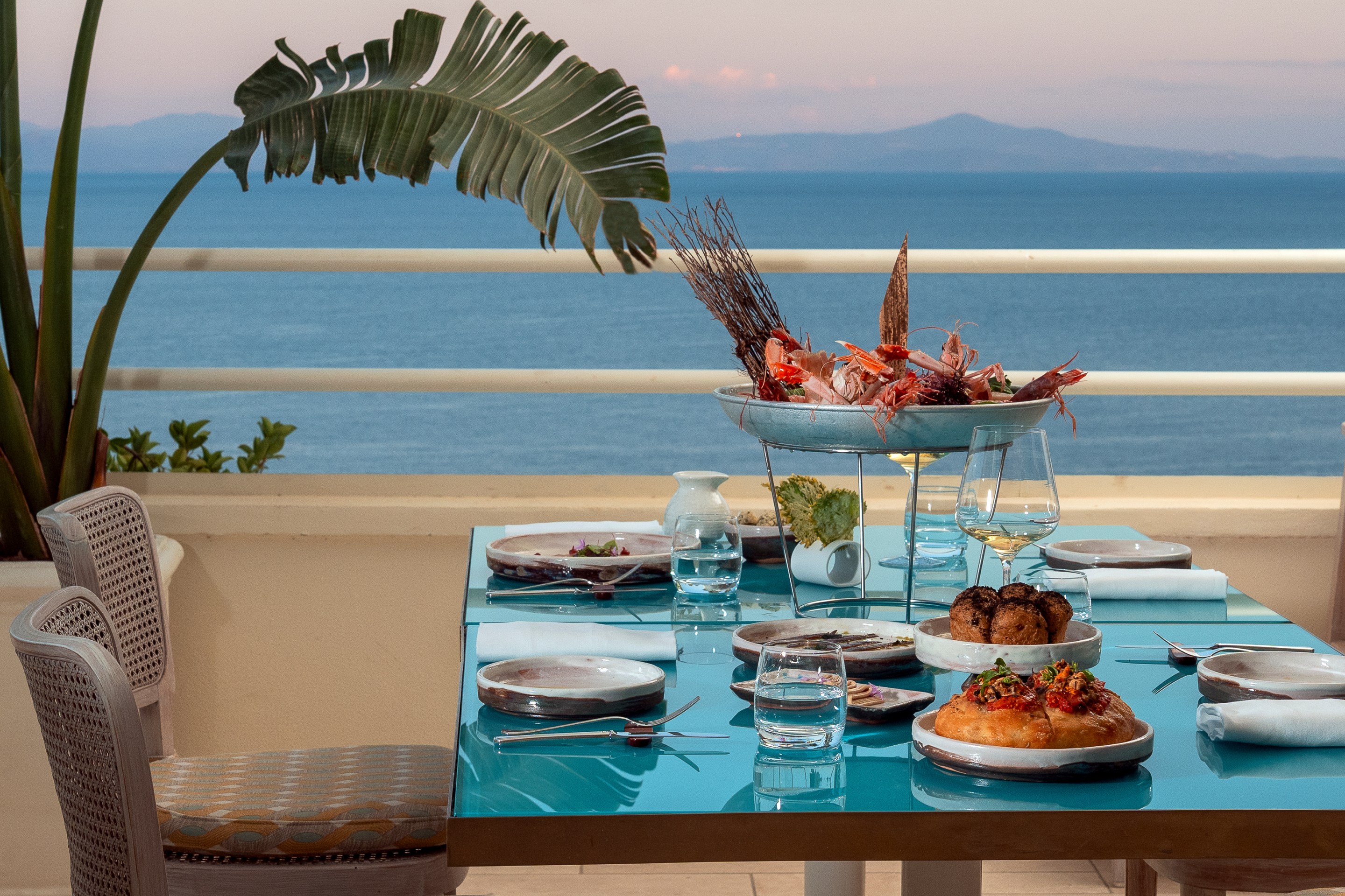 Dining table at Senzafine with seafood platter and view of Amalfi coastline