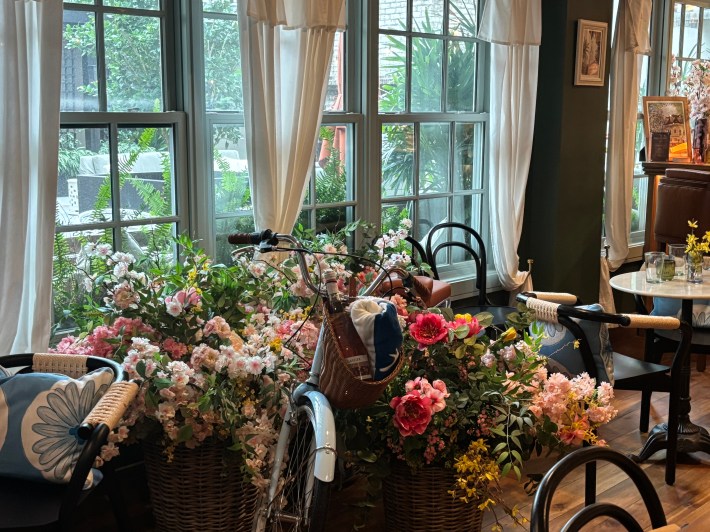 Interior of Frannie & The Fox with floral bicycle display by the window in Charleston