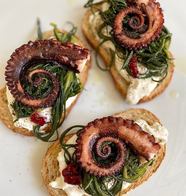 rostini topped with octopus, greens, and cream at CasaSalvo restaurant in SoHo.