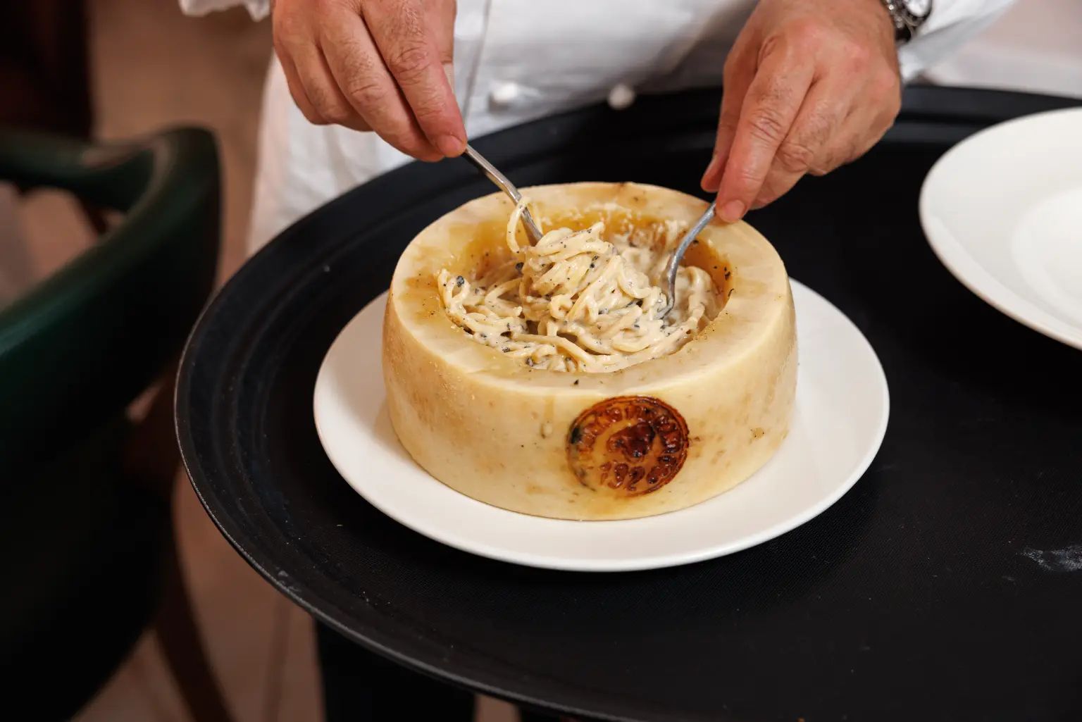 Fresh pasta being finished in a hollowed cheese wheel at CasaSalvo restaurant.
