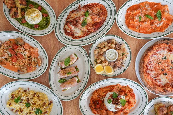 Overhead view of pasta, seafood, burrata, and pizza dishes