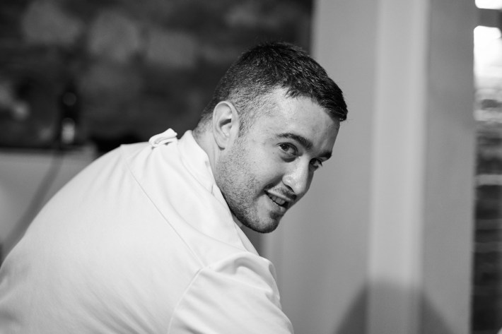 Chef Alessio Magliozzi working in the kitchen in his white coat.