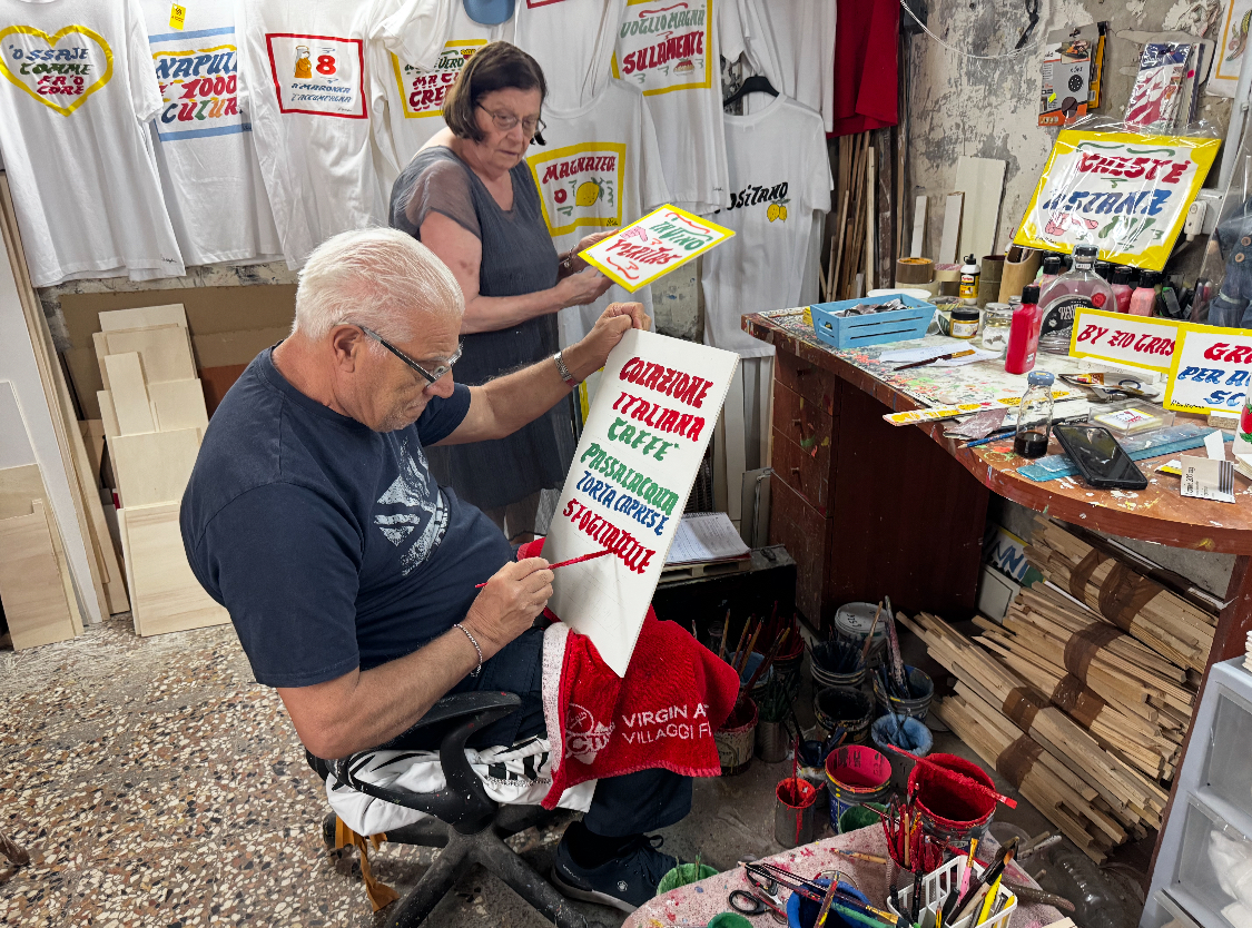 Pasquale De Stefano at work in his shop in Naples as his wife Anna looks on.