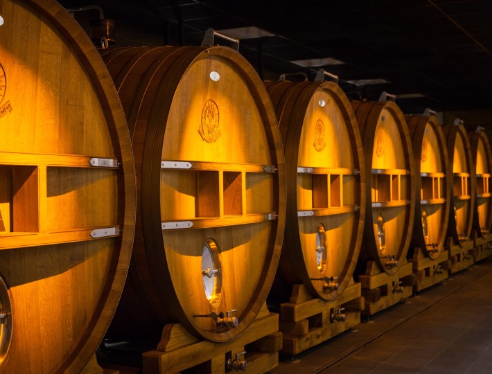 Rows of oak casks glowing in Champagne Telmont’s cellar