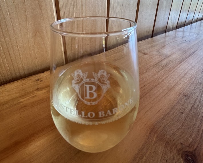 Castello Barone logo glass with white wine.