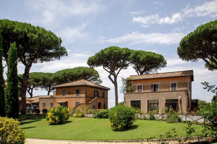 Villas surrounded by gardens and tall stone pines at Borgo Laudato Si’.