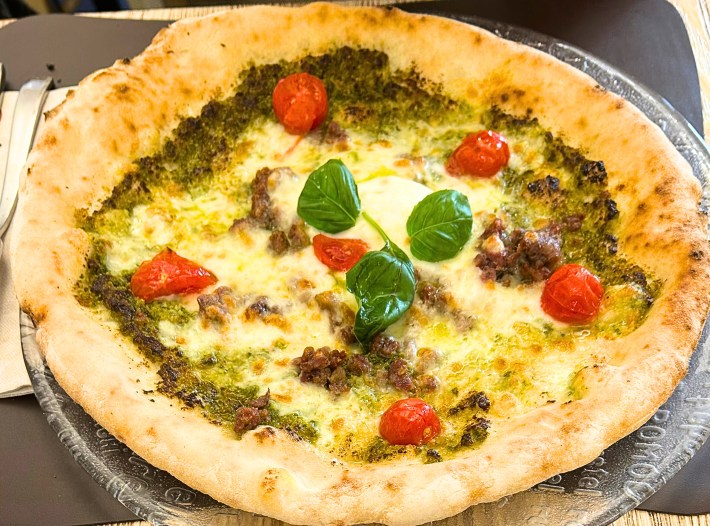 Gluten-free pizza tricolore at Mama Eat Milano, topped with tomatoes and basil.