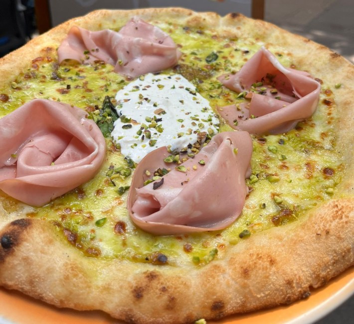 Neapolitan pizza at Peperino e Milan, topped with pistachios and a golden crust.