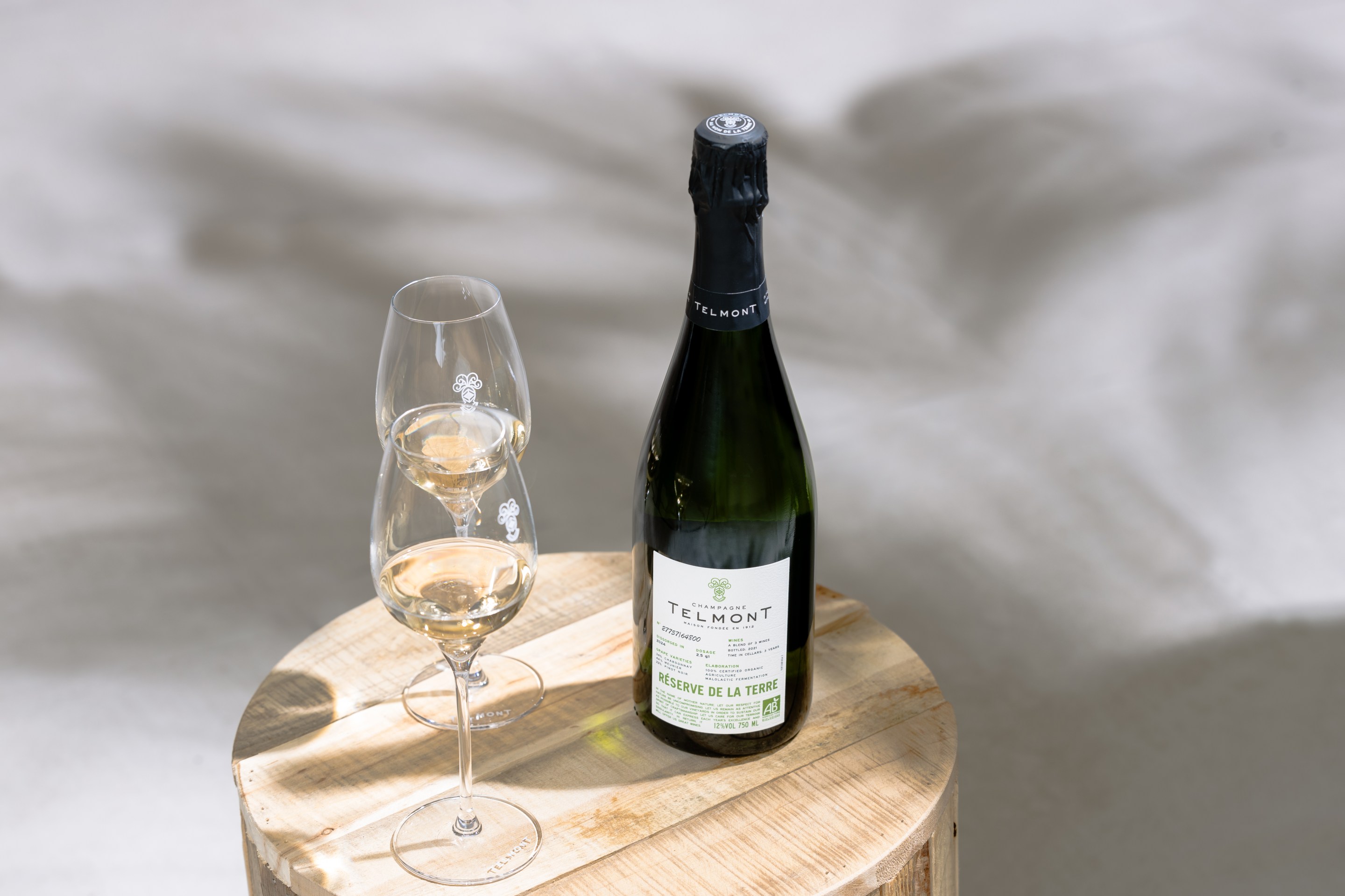 Bottle of Champagne Telmont Réserve de la Terre with glasses