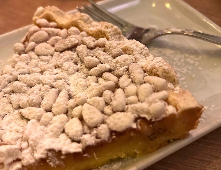 Torta della Nonna at Bistro, a flakey gluten-free pie topped with a pine nuts and filled with custard.