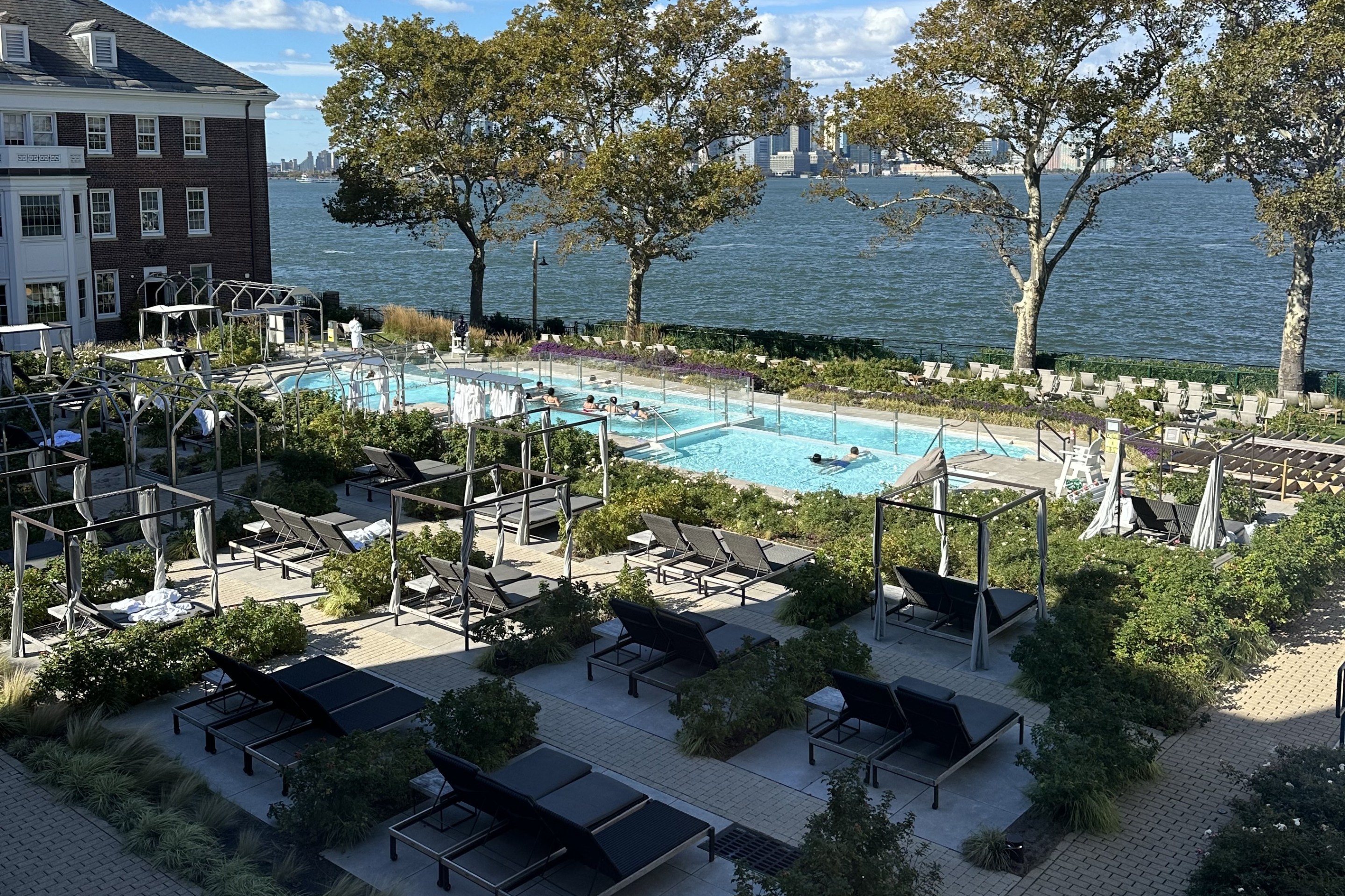 Outdoor heated pools at QC Spa NYC with city skyline views.