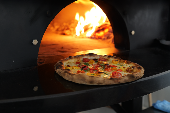 Pizza baking in a wood-fired oven at Anna’s Vesuviano, a Brooklyn-inspired Italian pizzeria in Providence.
