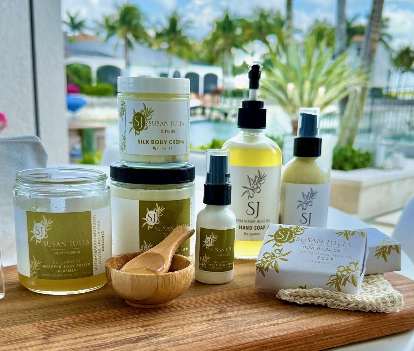 Assorted Susan Julia Olive Oil skincare products arranged on a wooden board