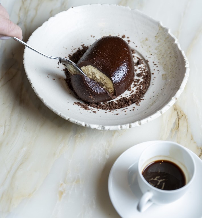 Tiramisu dessert topped with chocolate shell and espresso cup at Bottega Napa Valley.