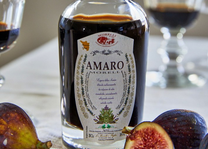 Bottle of Amaro Morelli liqueur with figs on a table in Tuscany.