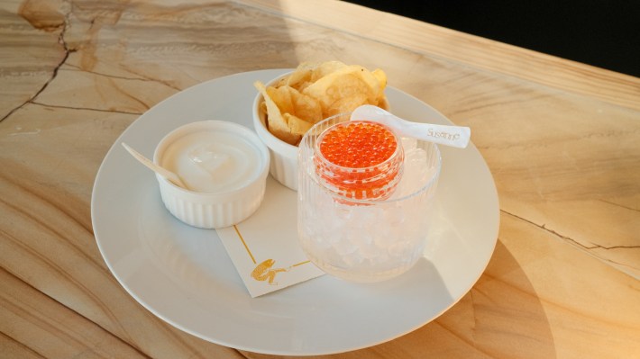 Plate at Cafe Susanne with trout roe on ice, potato chips and a ramekin of creme fraiche.