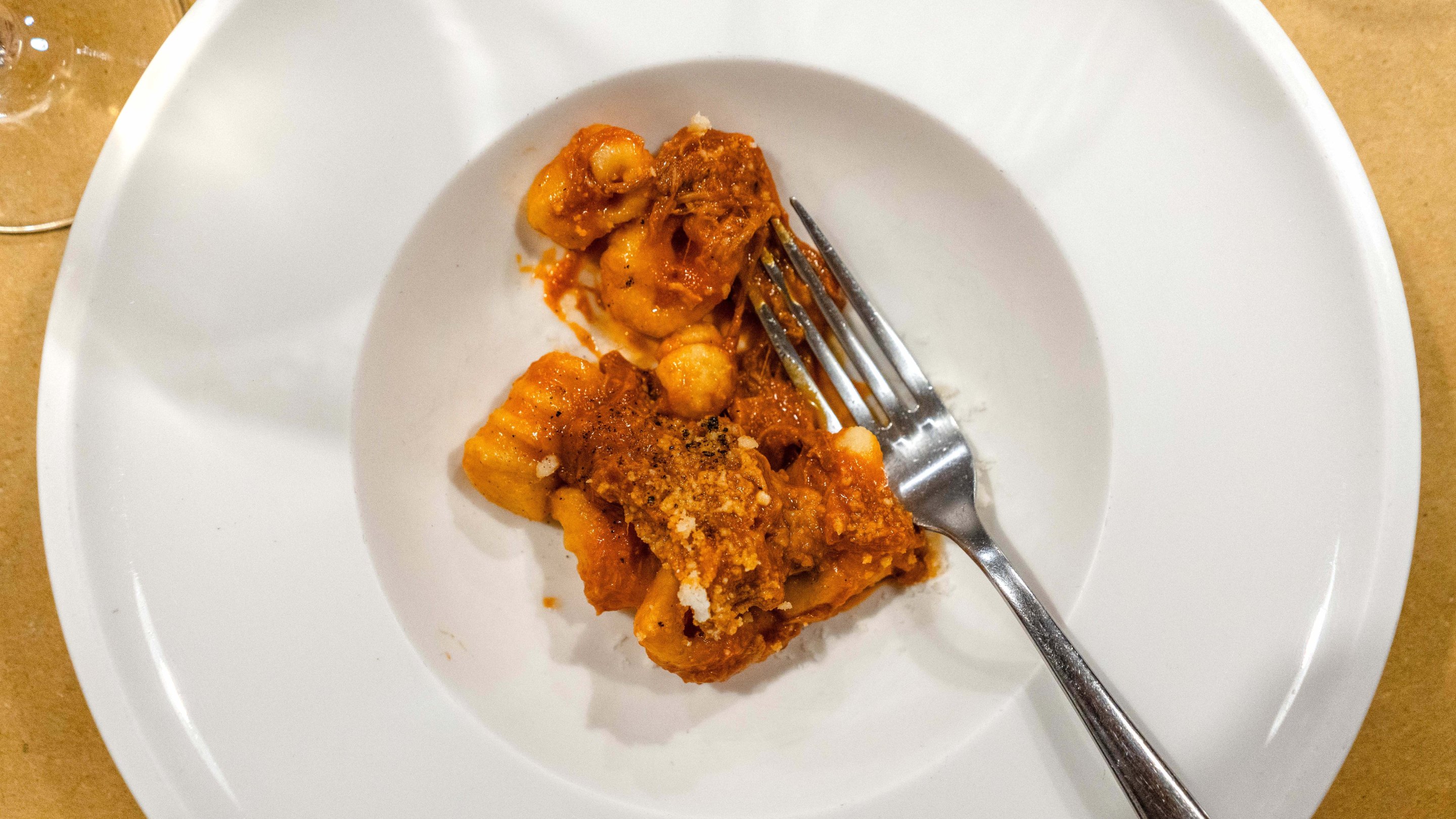 Gnocchi served with slow-cooked ragù on a white plate.