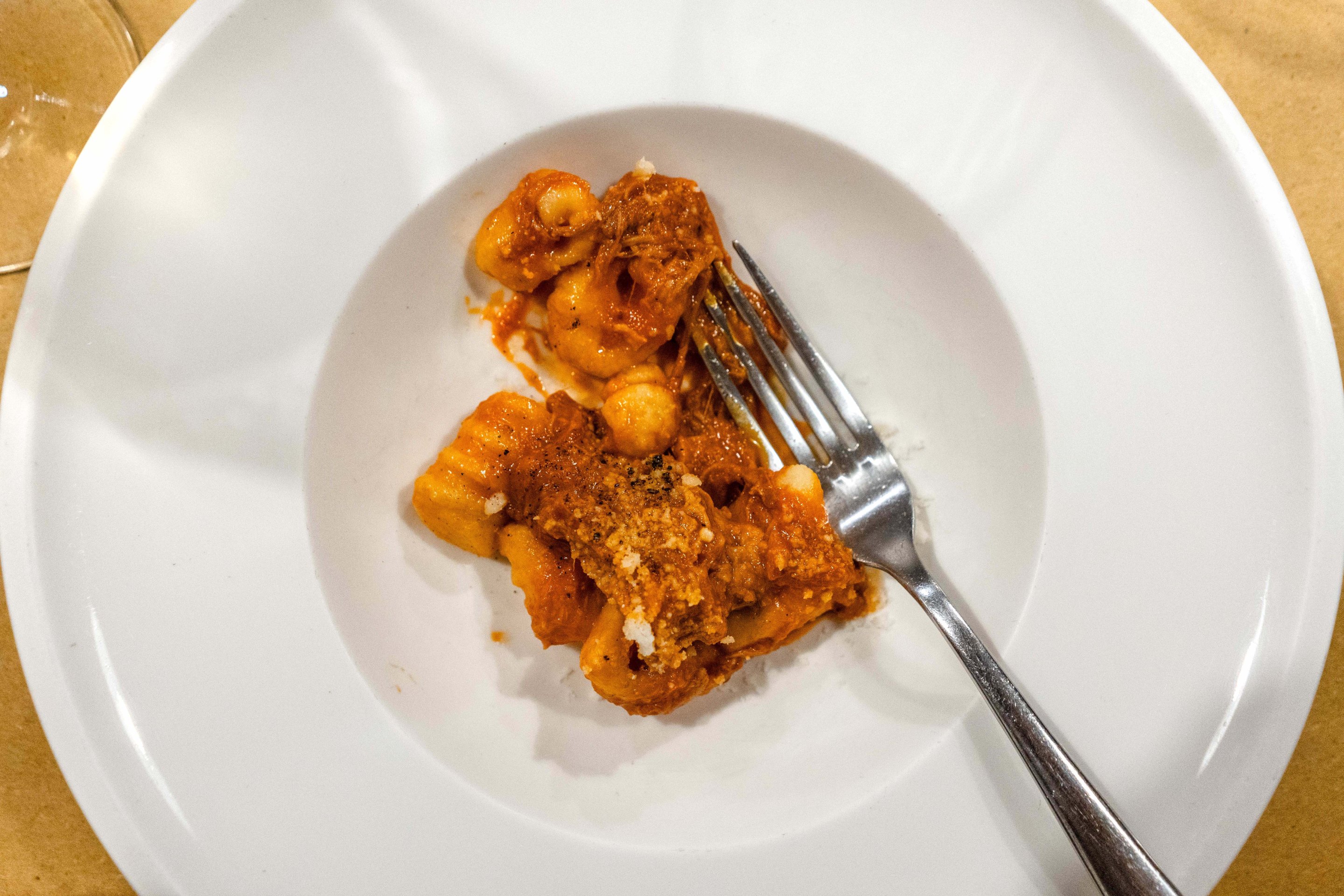 Gnocchi served with slow-cooked ragù on a white plate.